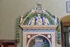 View of the top with Madonna and Child with angels in the tympanum and long colored garlands of fruit and flowers
