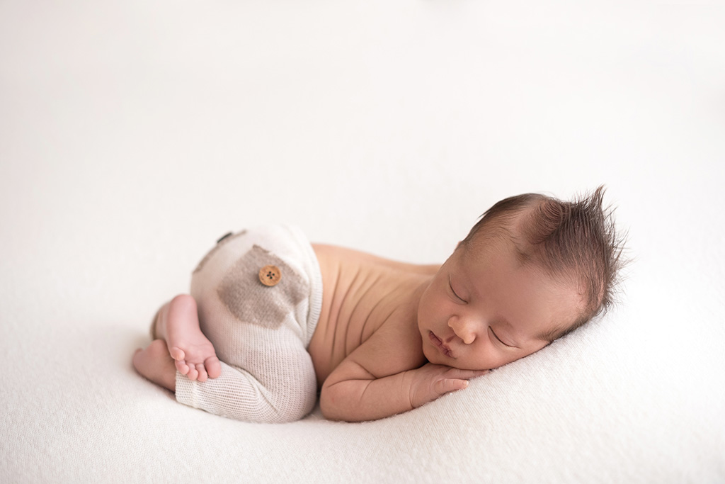 foto de recém-nascido no puff, pose de bebê no puff, as melhores poses para ensaio newborn, foto newborn em estúdio, quais poses para fotos newborn
