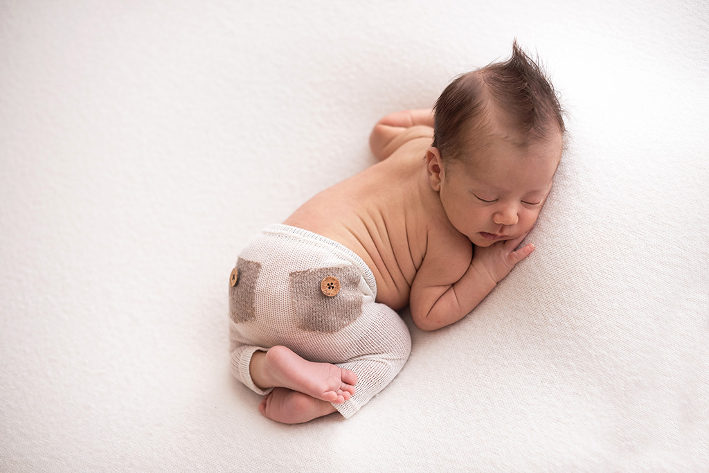 foto de recém-nascido no puff, pose de bebê no puff, as melhores poses para ensaio newborn, foto newborn em estúdio, quais poses para fotos newborn