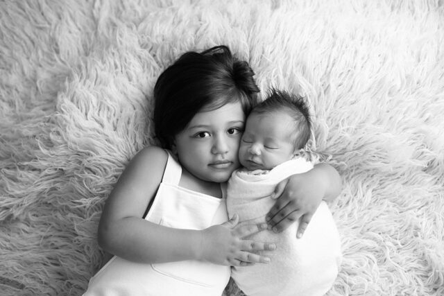 foto de recém-nascido com irmãos, pose de bebê no puff, as melhores poses para ensaio newborn, foto newborn em estúdio, quais poses para fotos newborn