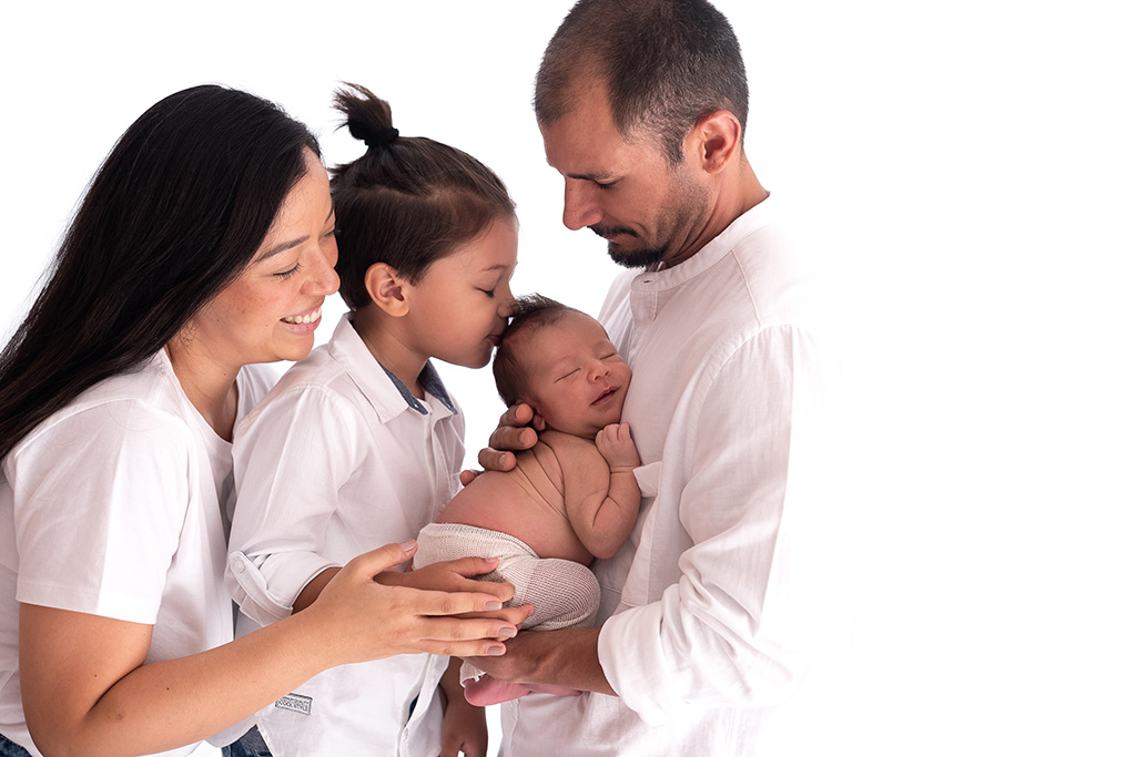 foto de recém-nascido com a família, pose de bebê no puff, as melhores poses para ensaio newborn, foto newborn em estúdio, quais poses para fotos newborn