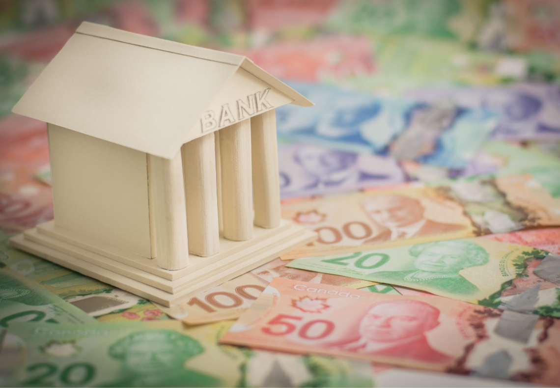 image of a bank figurine on top of Canadian money