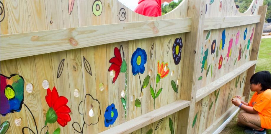 A fence painted with colorful flowers in the Outer Banks