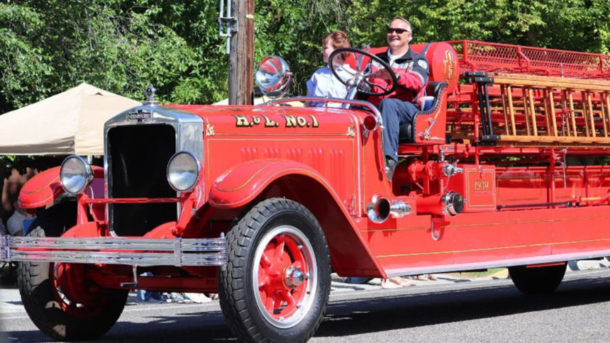 IFFD Deputy Fire Chief Dave Coffey and wife, Michele Coffey, behind the wheel of the old ladder truck during the Independence Day parade (2019).