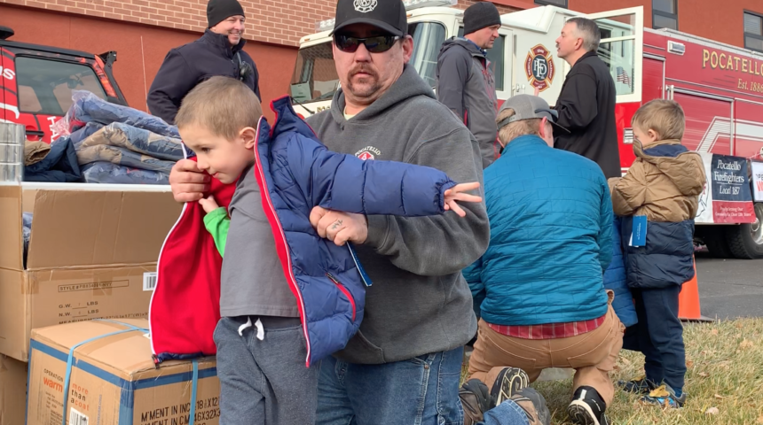 kid trying on coat from firefighter