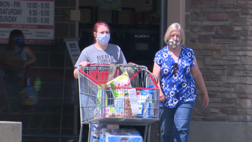 two women wearing masks as they leave costco