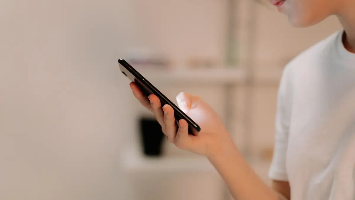 Pessoa ajustando o tamanho da letra na tela de um celular