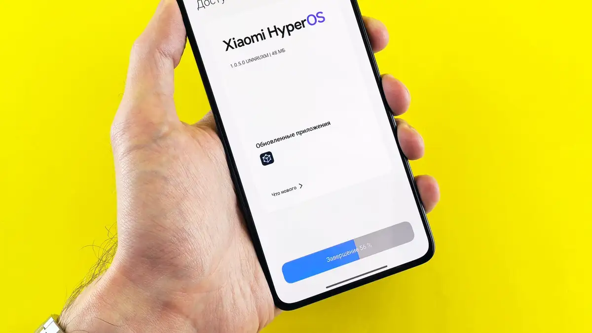 Mão segurando um celular exibindo a tela de atualização do sistema