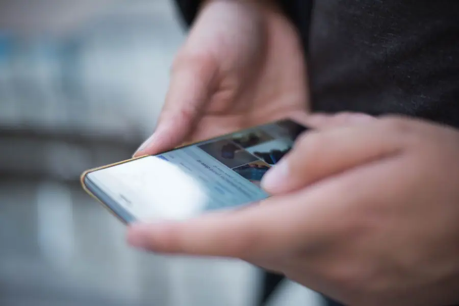 Mãos usando a tela sensível ao toque de um smartphone Mãos usando a tela sensível ao toque de um smartphone
