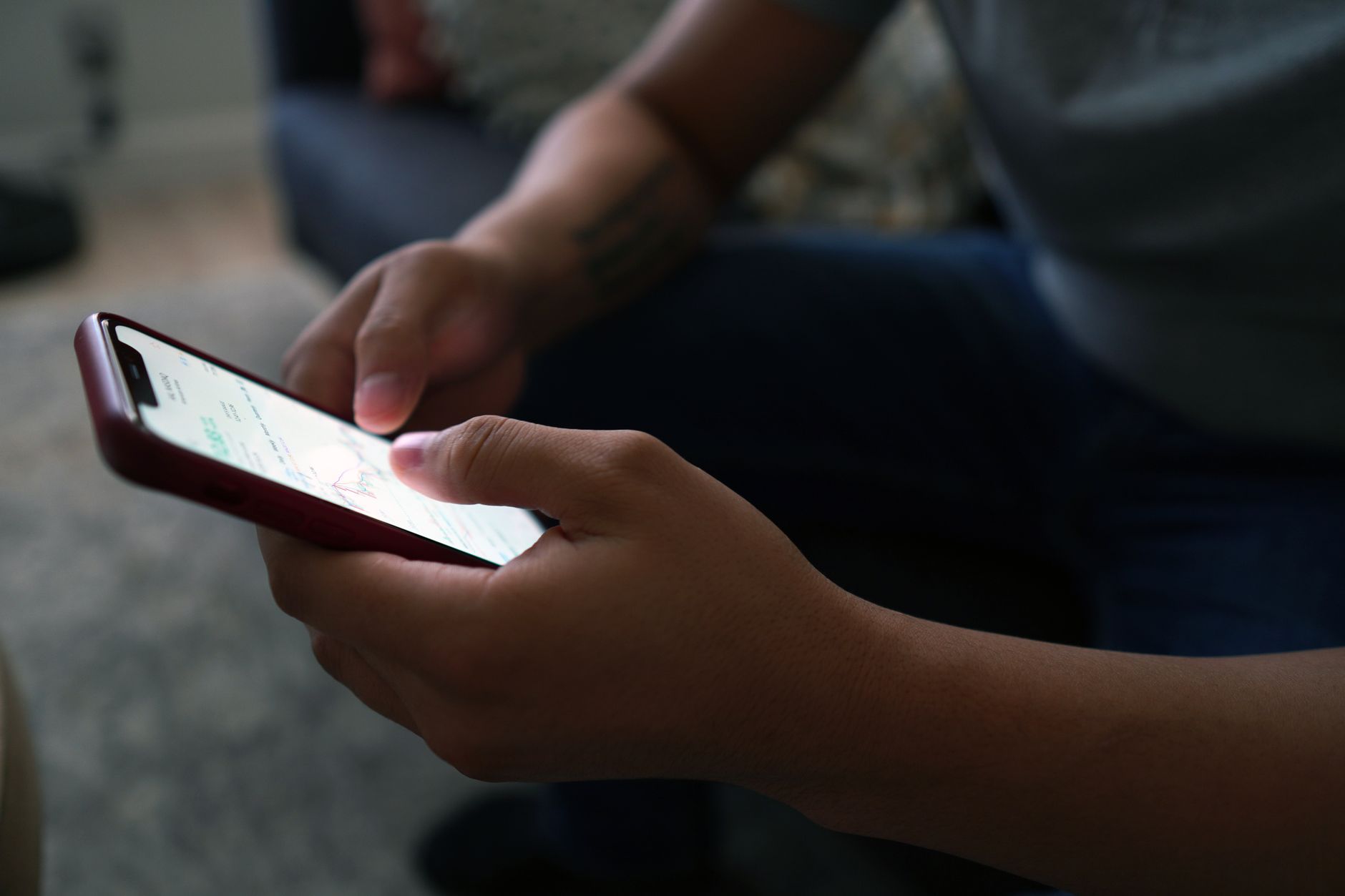Pessoa segurando um celular enquanto compara informações sobre a bateria.