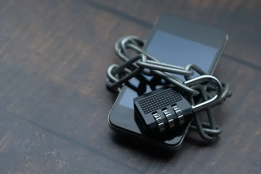 Mãos segurando um smartphone com cadeado de segurança na tela Mãos segurando um smartphone com cadeado de segurança na tela