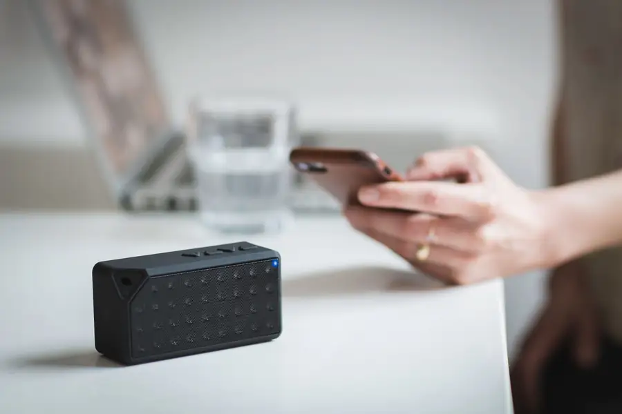 Mão segurando um celular com ícones de conexão sem fio na tela Mão segurando um celular com ícones de conexão sem fio na tela
