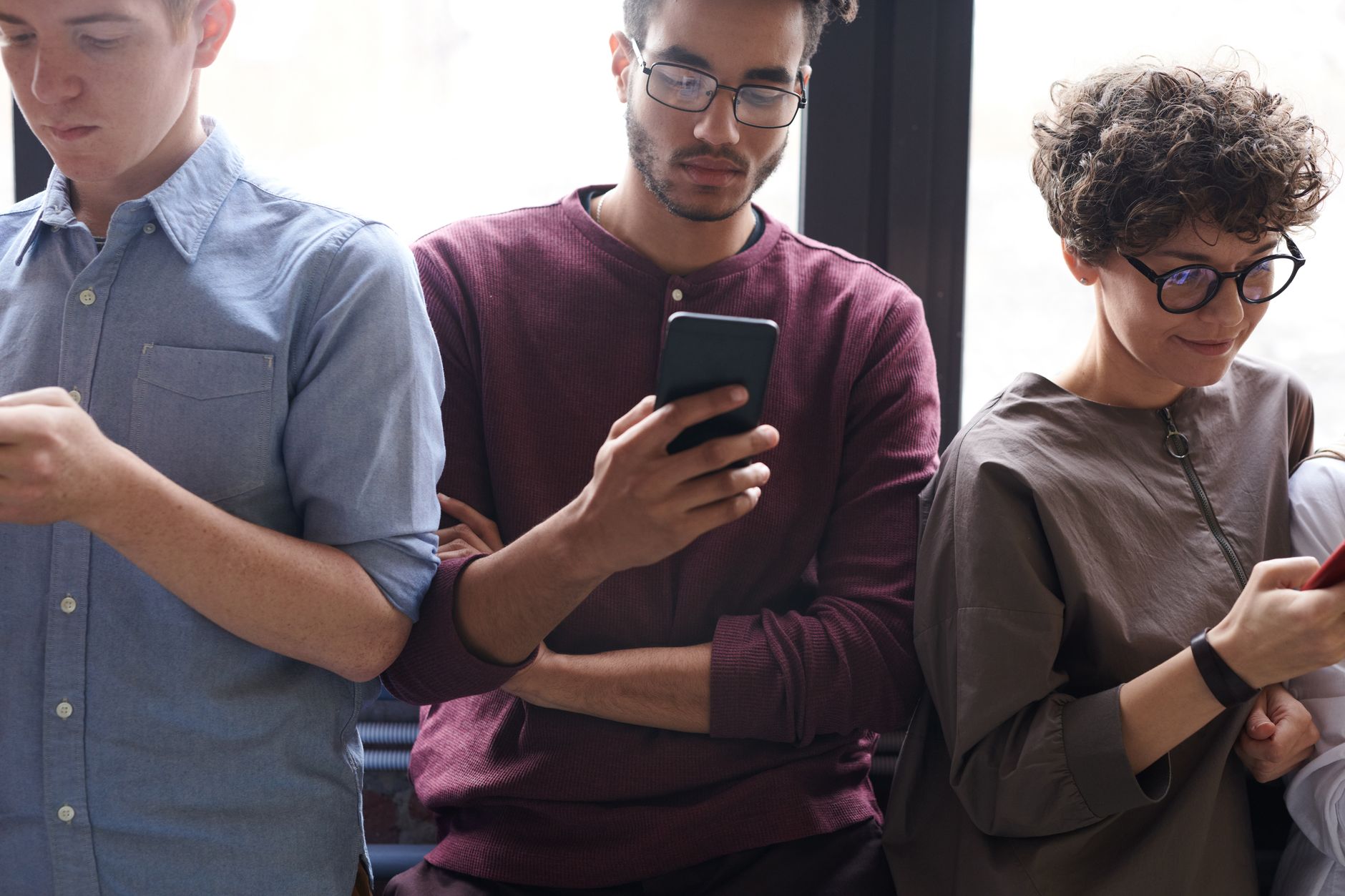 Calendário da Apple: quando cada produto é anunciado A diverse group of people actively using smartphones indoors. Modern technology and social interaction.