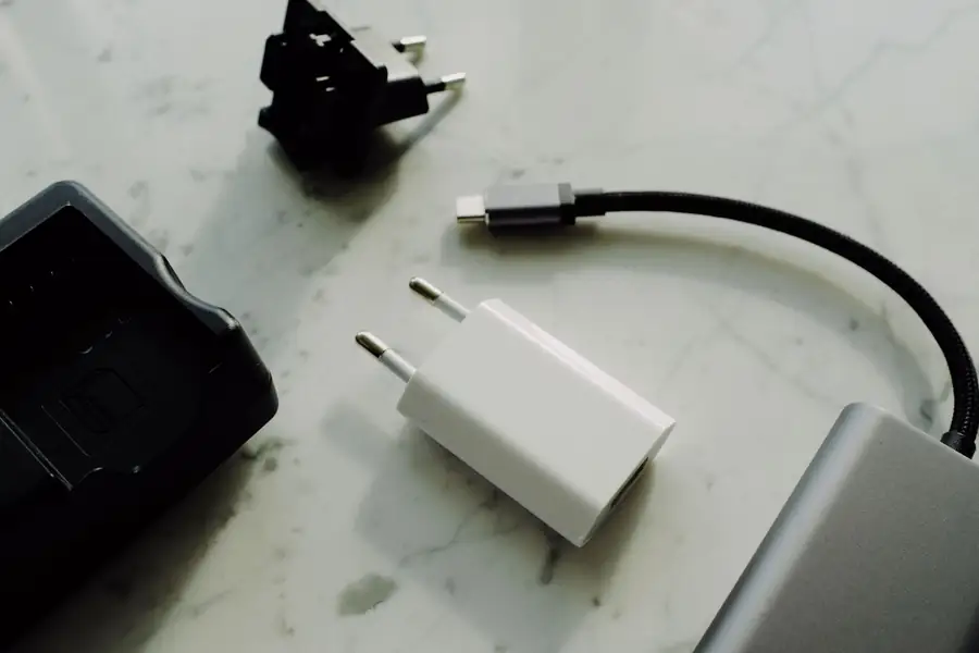 Carregador portátil e cabo USB sobre uma mesa ao lado de um celular Carregador portátil e cabo USB sobre uma mesa ao lado de um celular