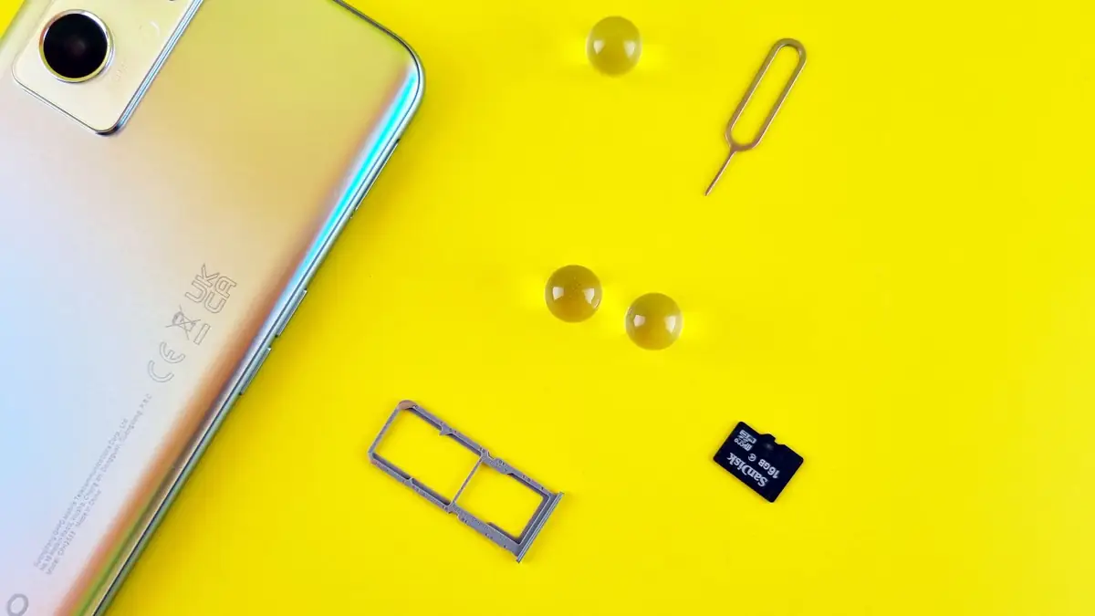 Celular com bandeja aberta mostrando chip e cartão de memória microSD