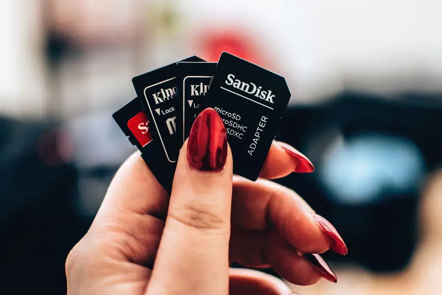 Mão segurando cartões microSD de diferentes capacidades Mão segurando cartões microSD de diferentes capacidades