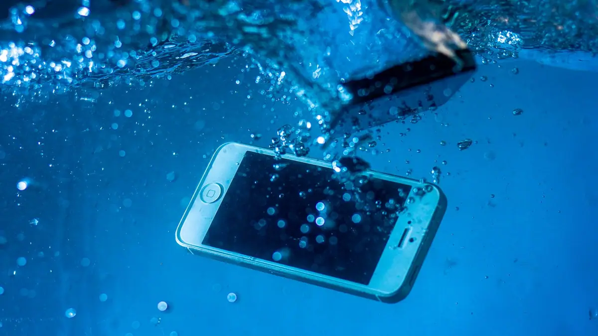 Smartphone submerso em água com bolhas ao redor