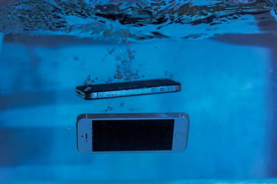 Dois smartphones submersos na água em um teste de resistência Dois smartphones submersos na água em um teste de resistência