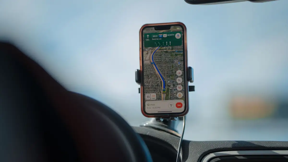 Celular fixado no painel de um carro mostrando navegação por GPS
