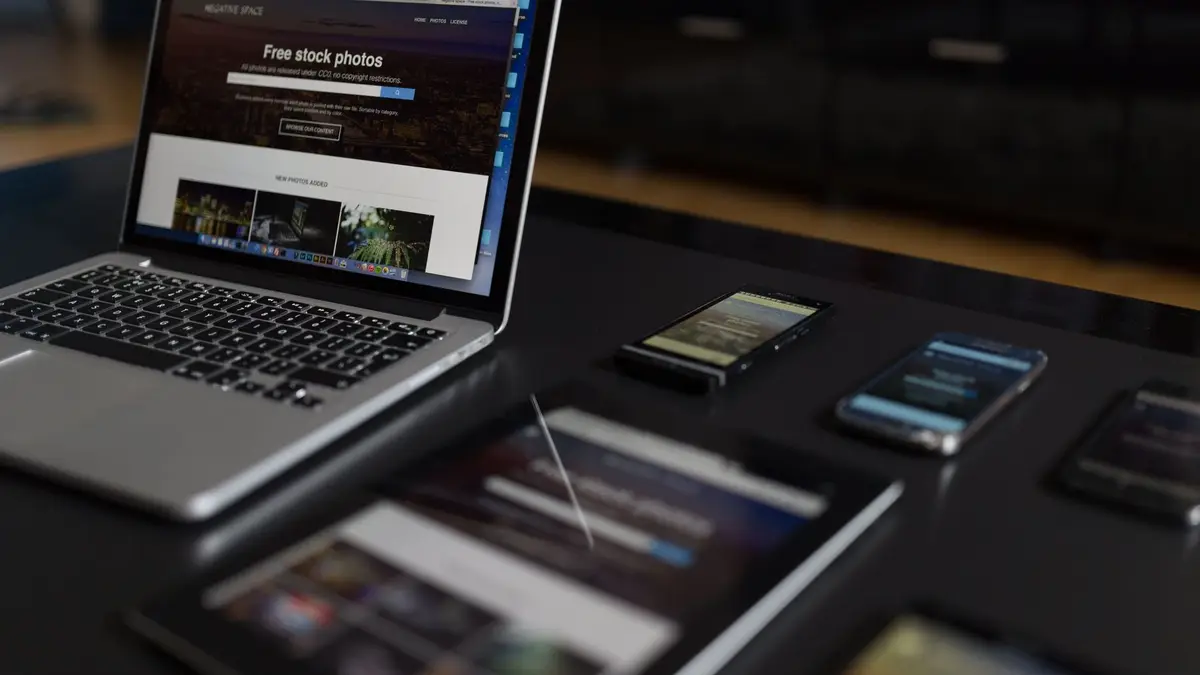 Notebook, tablet e celulares sobre uma mesa de trabalho