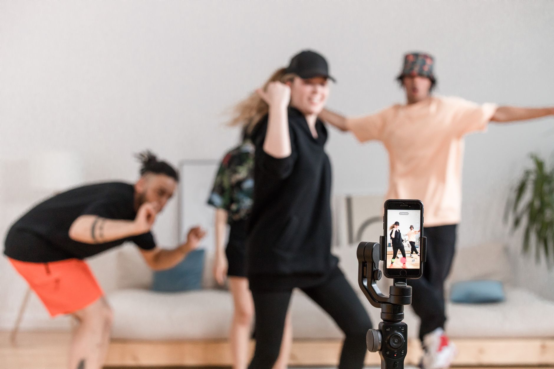 Como gravar vídeo estável com o celular A diverse group having fun dancing for social media video content indoors.