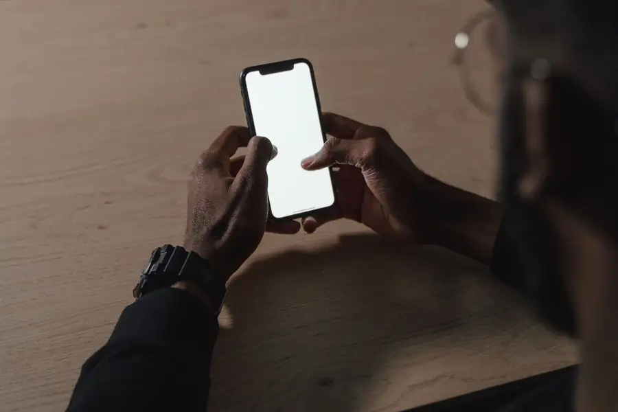 Pessoa usando o polegar para alcançar aplicativos na parte de baixo da tela do celular Pessoa usando o polegar para alcançar aplicativos na parte de baixo da tela do celular