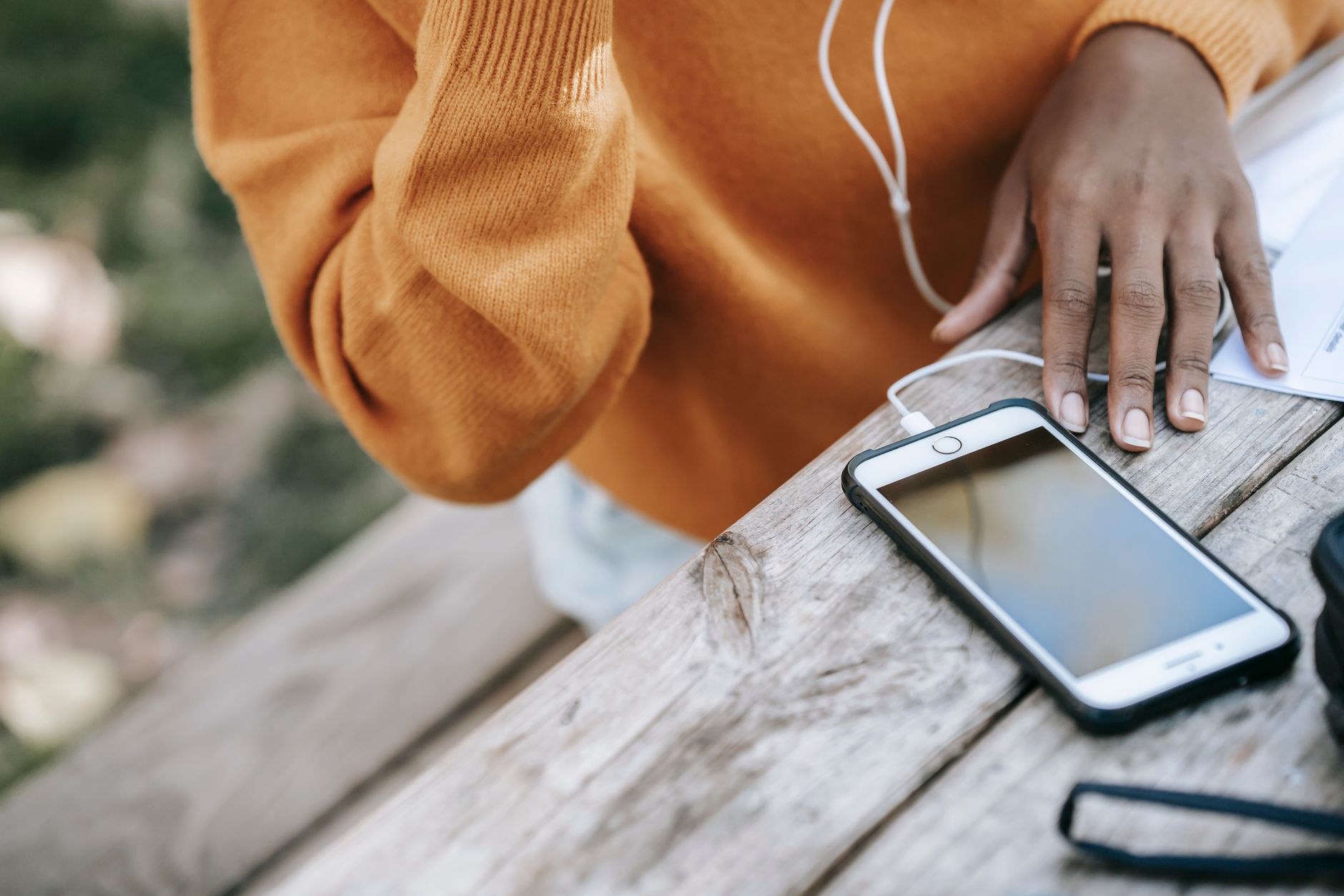 Pessoa deixando o celular sobre a mesa enquanto realiza outra atividade