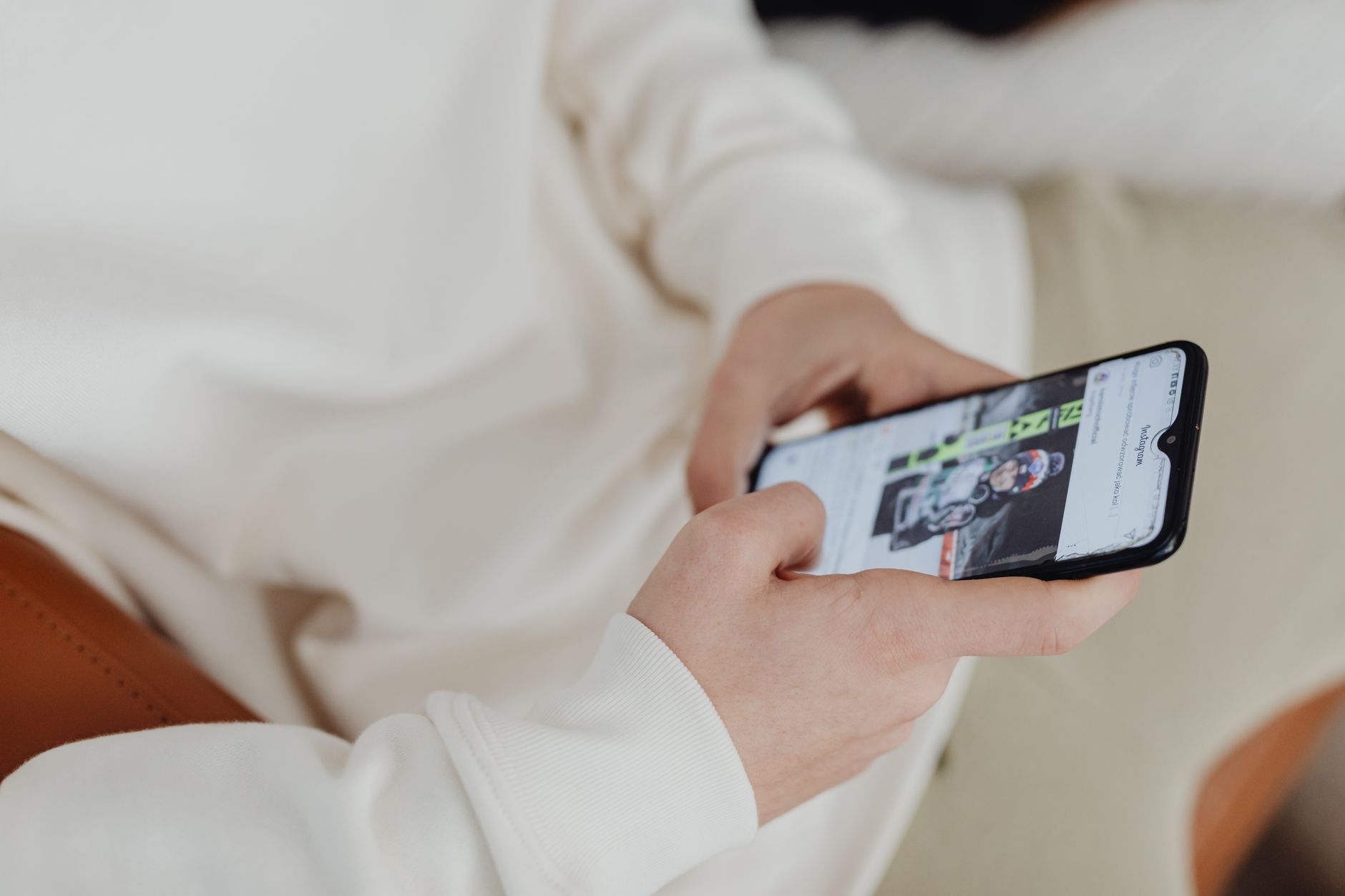 Pessoa segurando um celular enquanto usa uma rede Wi-Fi dentro de casa