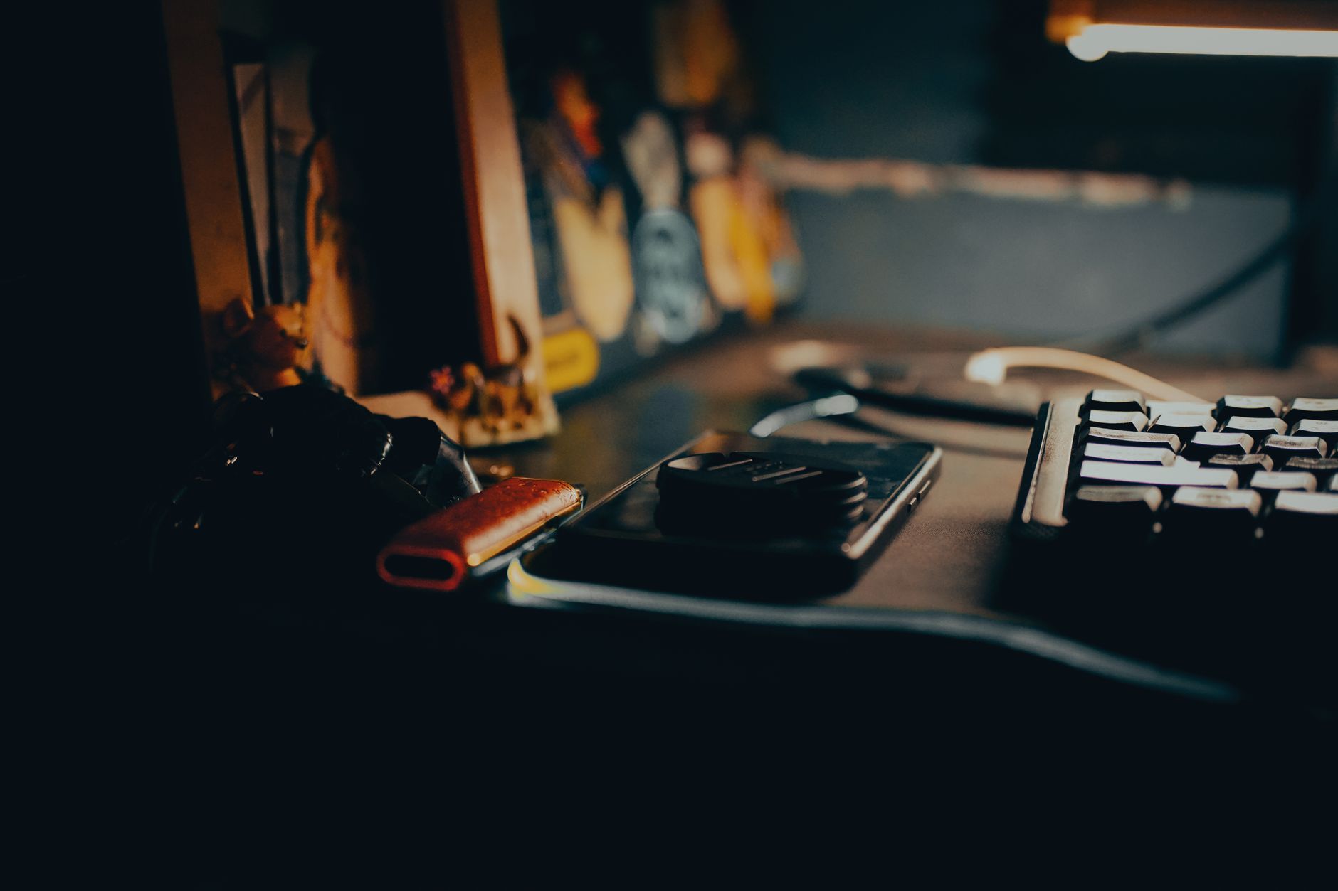 Chamadas por Wi-Fi: como ativar e quando usar A dimly lit workspace featuring a keyboard, gadgets, and a warm ambient glow.