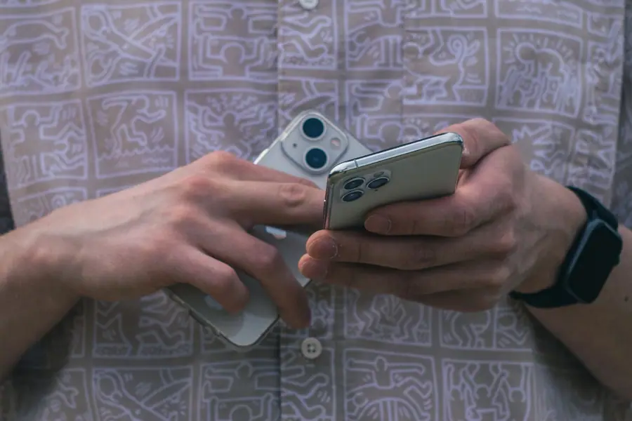 Mãos segurando dois smartphones para comparação Mãos segurando dois smartphones para comparação
