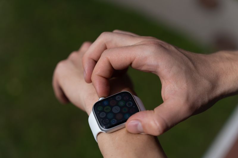 Como preencher a ficha médica na tela de bloqueio do celular Detailed view of a hand interacting with a smartwatch outdoors.