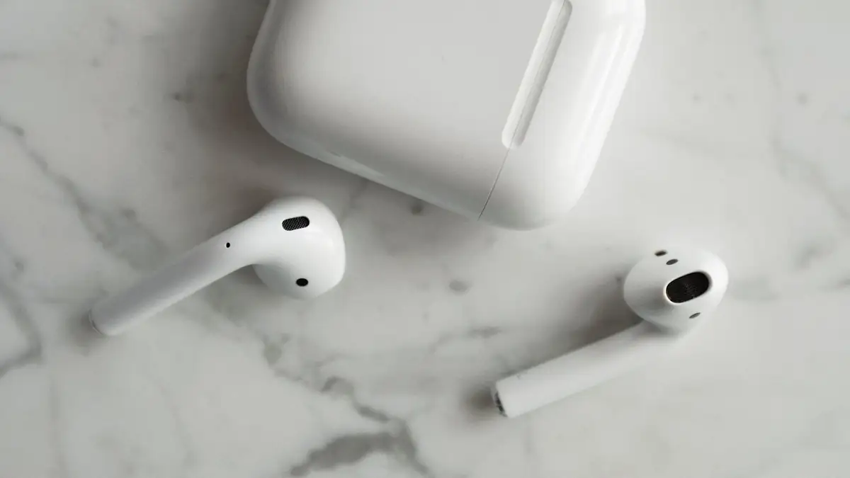 Fones de ouvido sem fio e estojo de carregamento sobre uma superfície de mármore