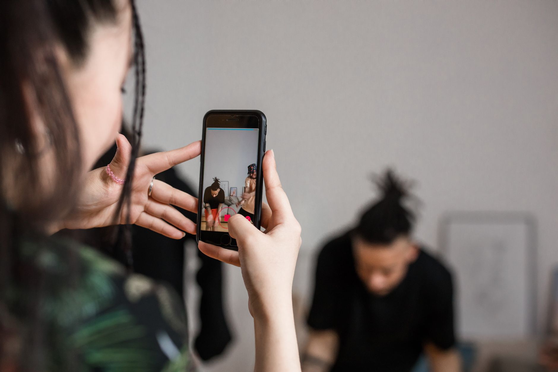 Galaxy A56 x A36: qual intermediário vale mais Close-up of a person recording a video with a smartphone indoors, focusing on creative content creation.