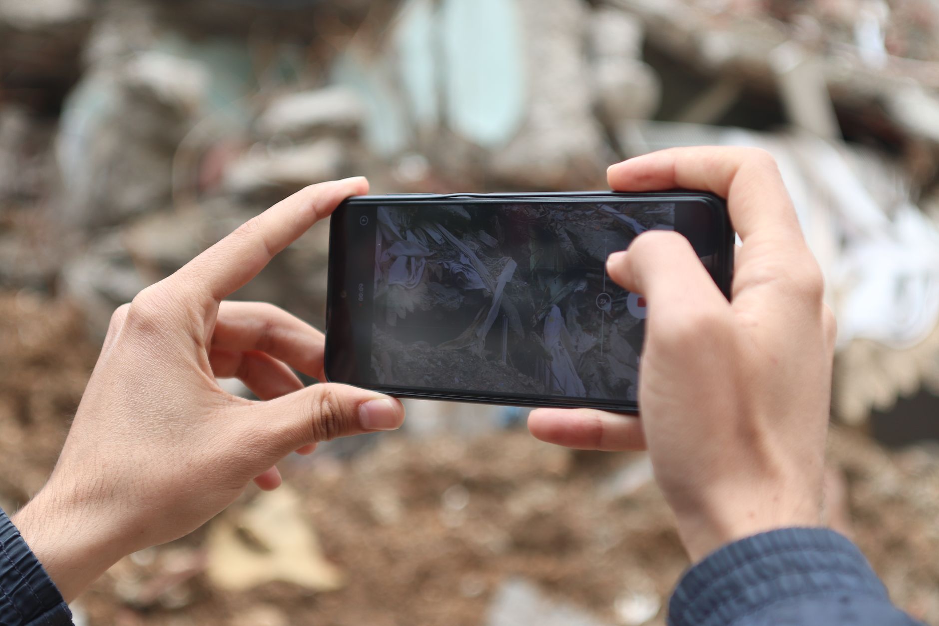 Close-up of hands photographing ruins with a smartphone outdoors.