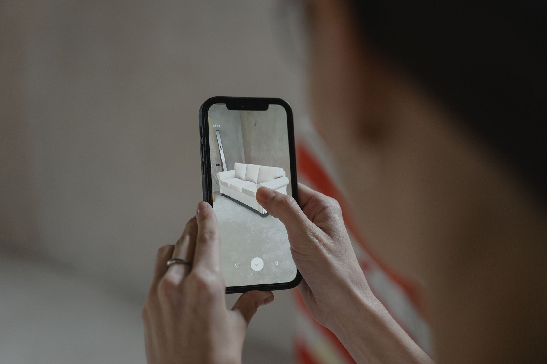 Galaxy S x Galaxy A: entenda a diferença Person using augmented reality on smartphone to visualize a sofa in a room.