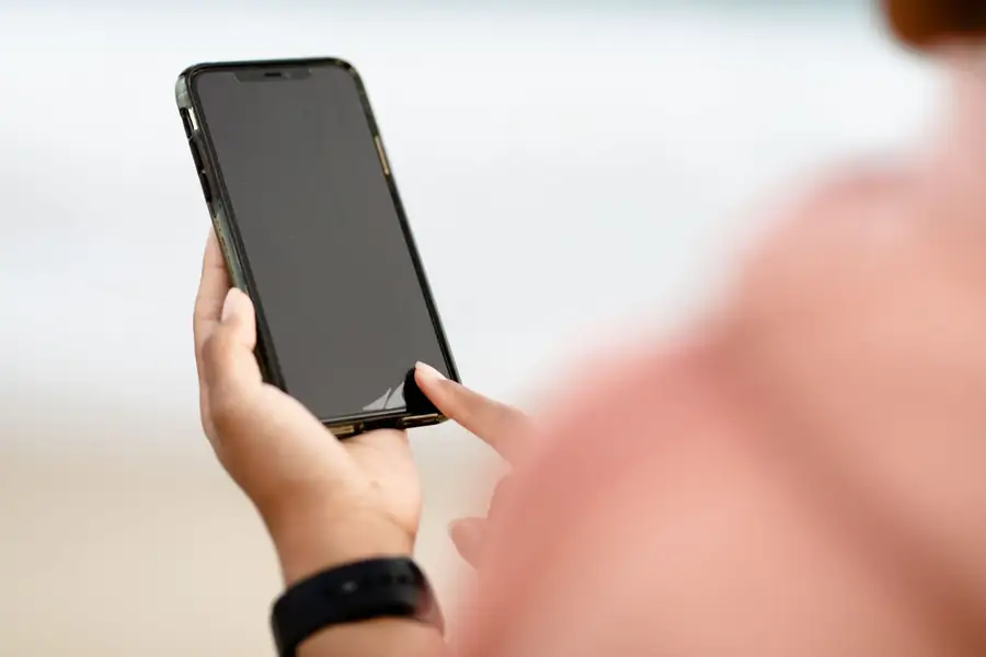 Pessoa tocando a tela de um smartphone com o dedo Pessoa tocando a tela de um smartphone com o dedo