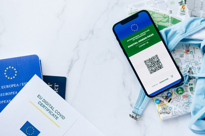 Golpe da troca de chip: como funciona e como se proteger EU digital COVID certificate with smartphone, passports, and map symbolizing travel and vaccination support.