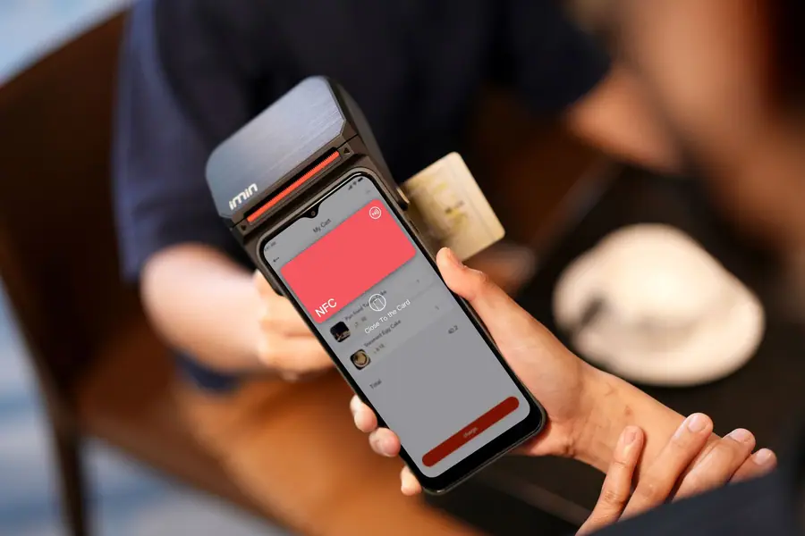 Aproximação de um smartphone em uma maquininha para pagamento por NFC Aproximação de um smartphone em uma maquininha para pagamento por NFC