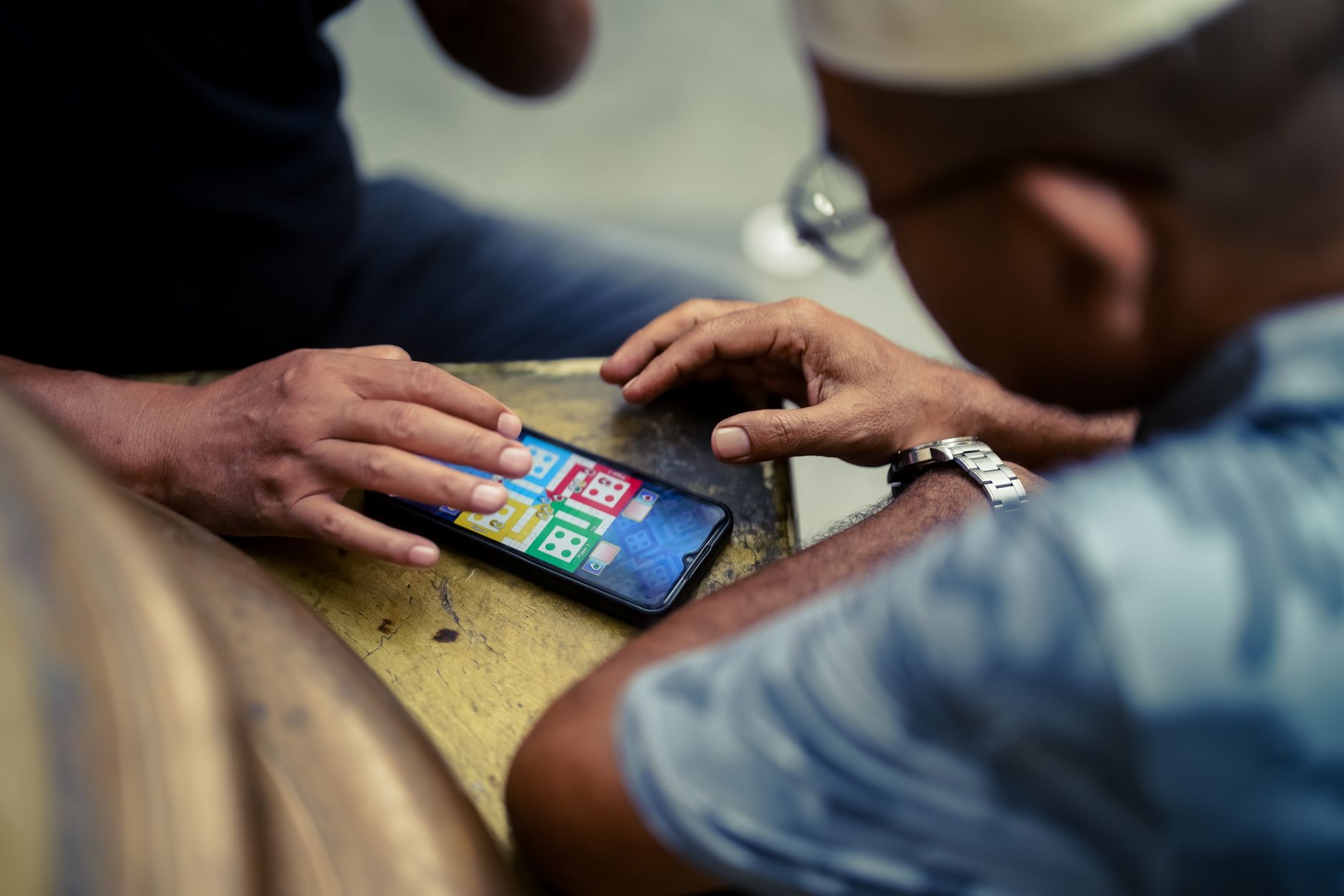 Pessoa segurando um celular enquanto toca na tela durante um jogo