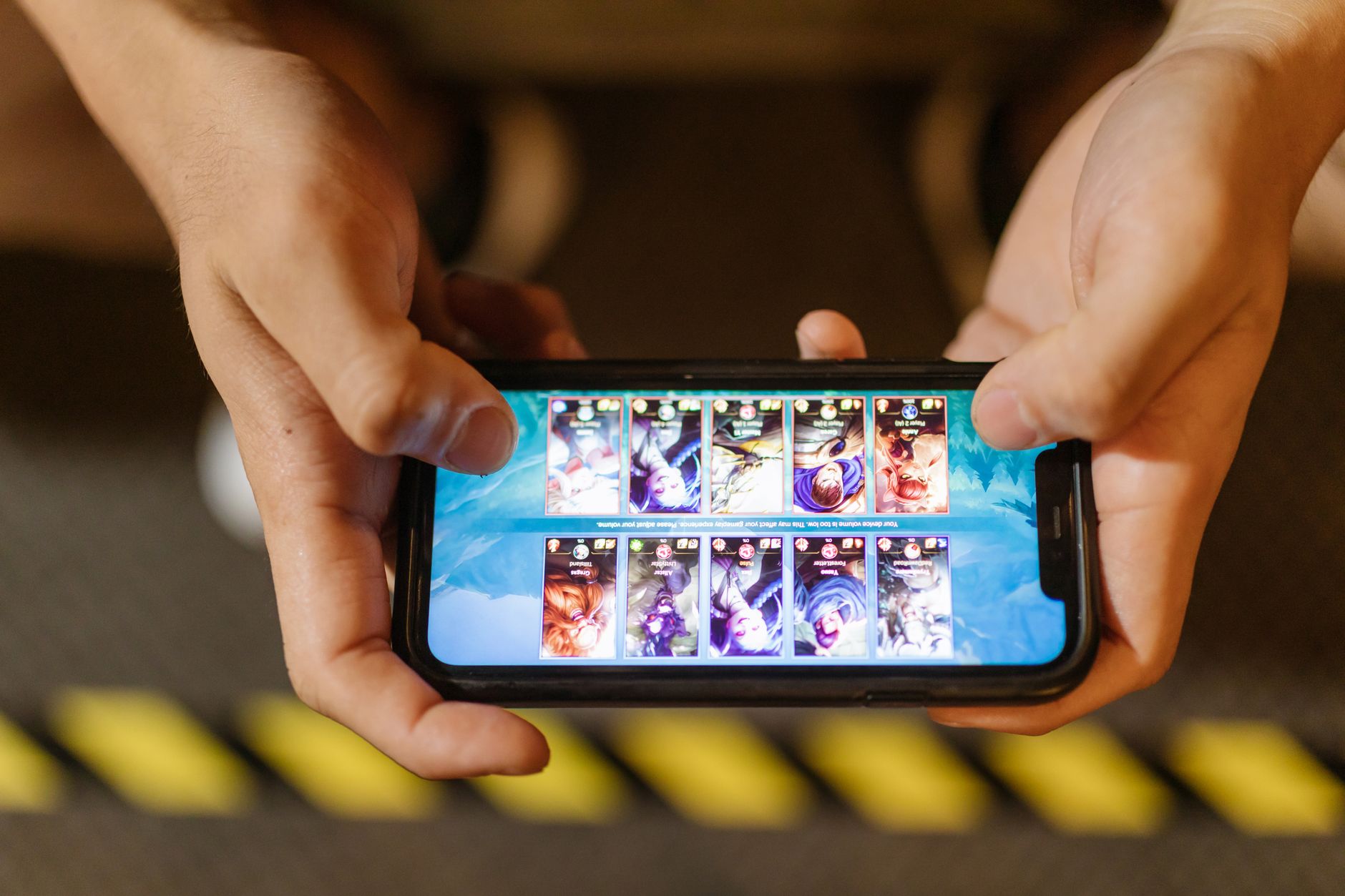 Como escolher o processador do celular sem se perder Close-up of hands playing a mobile game on a smartphone, showcasing the game's interface.