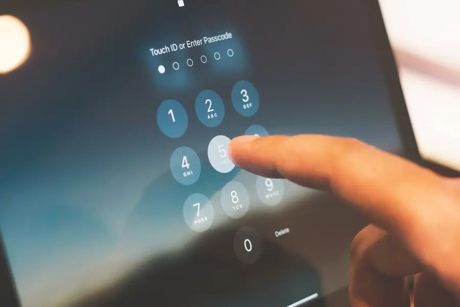 Dedo digitando uma senha na tela de segurança de um smartphone Dedo digitando uma senha na tela de segurança de um smartphone