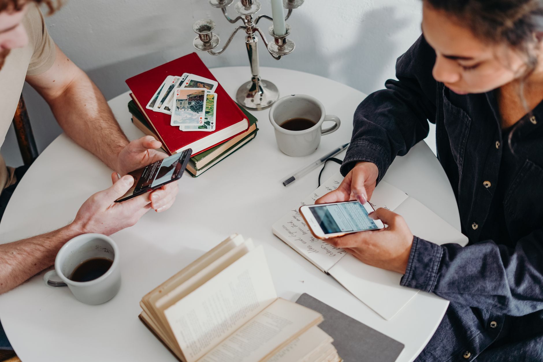 Pessoa segurando um smartphone enquanto compara recursos em uma mesa