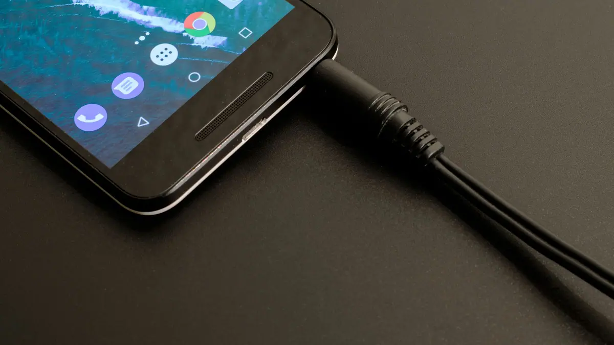 Smartphone sendo carregado em um fundo escuro