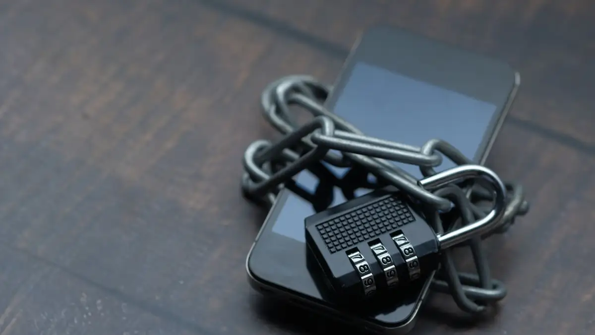 Celular envolto por uma corrente com cadeado, simbolizando segurança