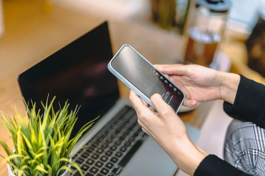 Mulher com um smartphone sobre um notebook em um escritório doméstico Mulher com um smartphone sobre um notebook em um escritório doméstico
