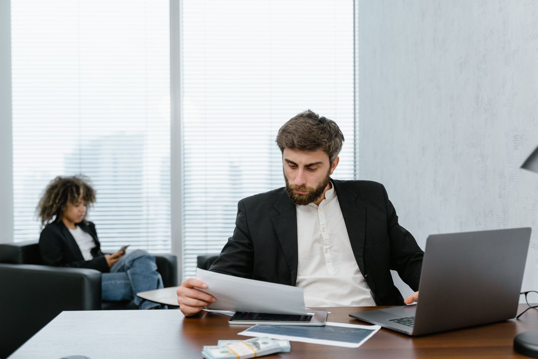 O que é o BCE e como ele influencia o euro Focused businessman reviews financial reports at office desk with laptop.