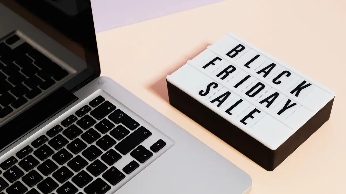 Placa de promoção da Black Friday ao lado de um notebook