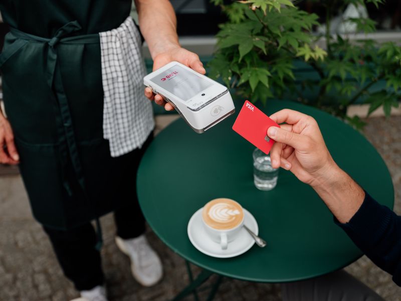 Customer making a seamless cashless payment at an outdoor café in Heidelberg, Germany.