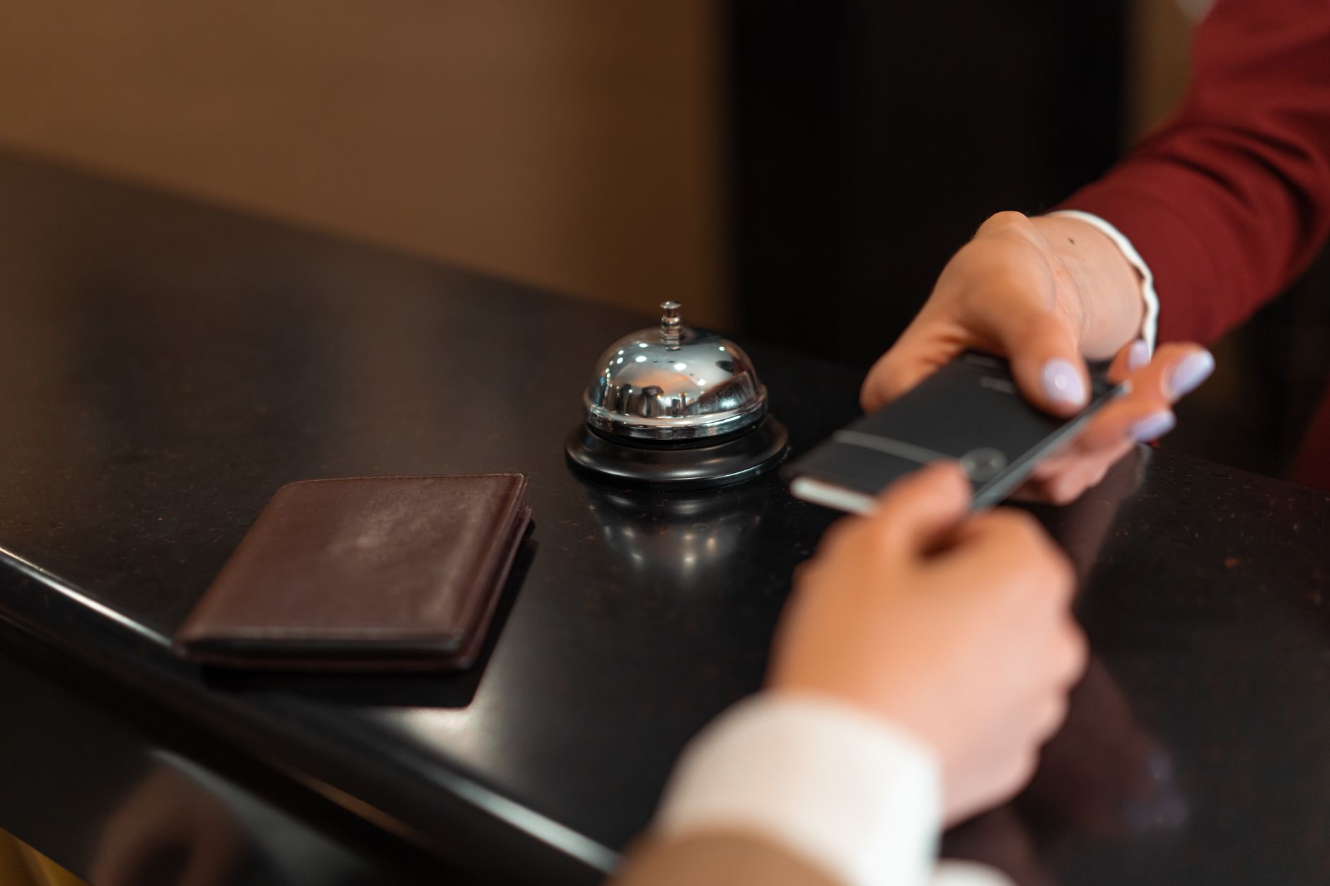 Pessoa entregando cartão internacional na recepção de um hotel na Europa.