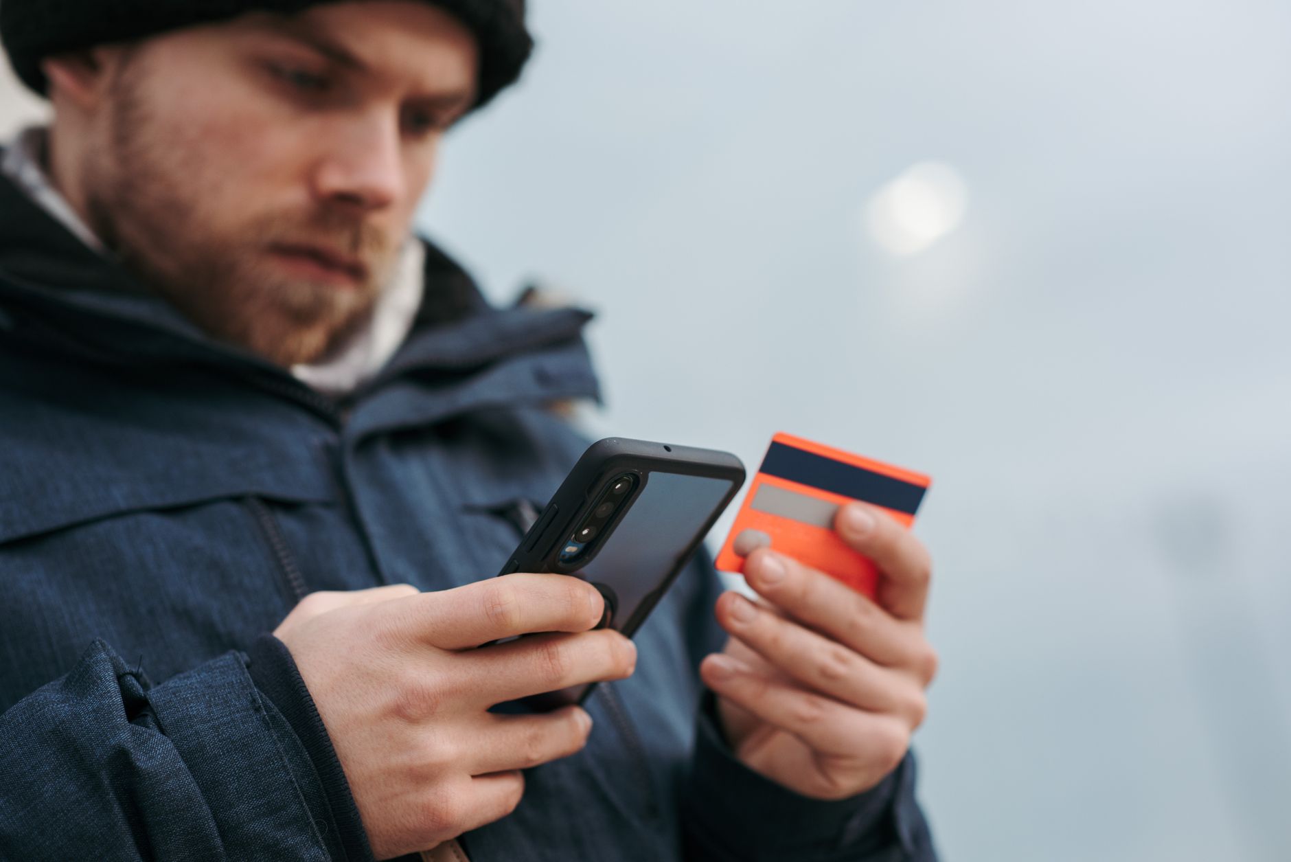 Pessoa usando o celular para pagar uma compra durante uma viagem pela Europa